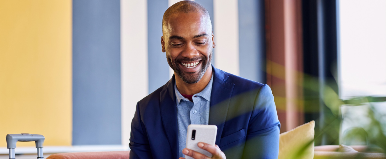 man reading something on his cell phone with a smile on his face