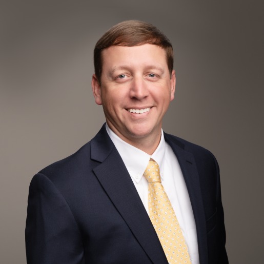 Steven in navy suit and gold tie.